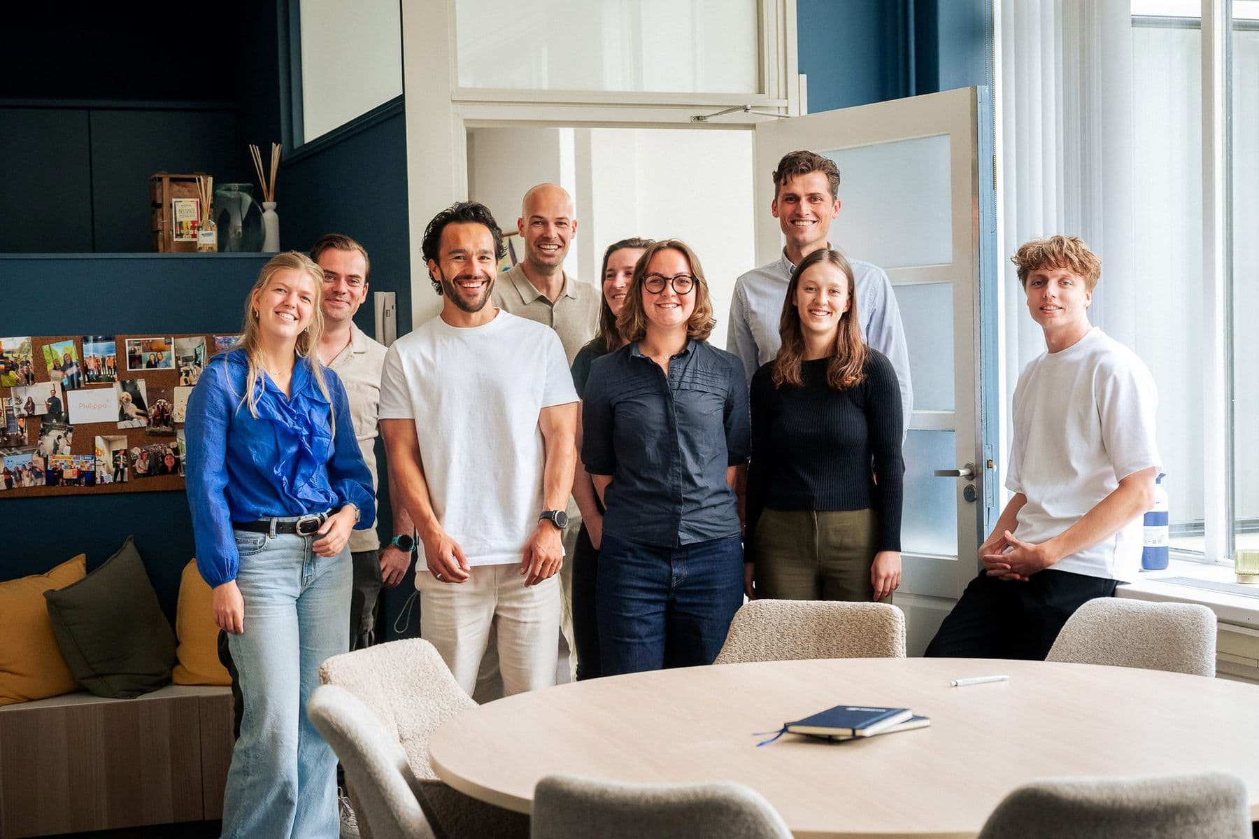 Het team van JoinSeven poseert lachend in de vergaderruimte van Villa Mooi Zeist