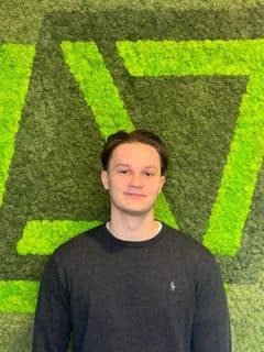 Portret van Robin, werkstudent data en marketing, voor een groene mosmuur
