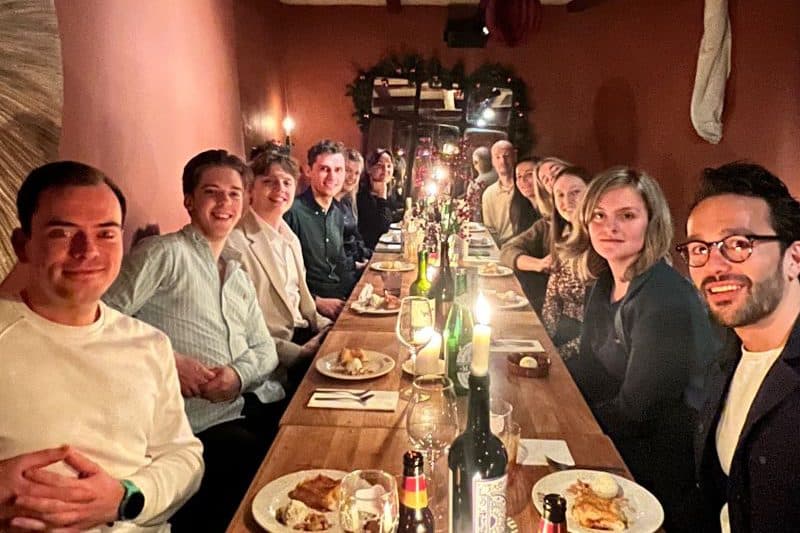 Collega's van JoinSeven aan een lange tafel tijdens het kerstdiner in Utrecht
