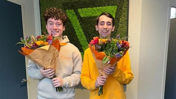 Daan Stuivenberg en Marten Fleuren met bloemen op hun eerste dag bij JoinSeven