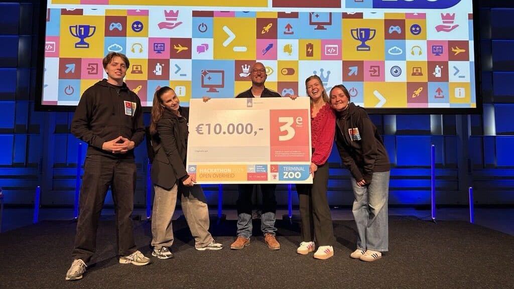 Het team van JoinSeven met de cheque voor de derde plaats op Terminal Zoo Open Overheid, in 2025