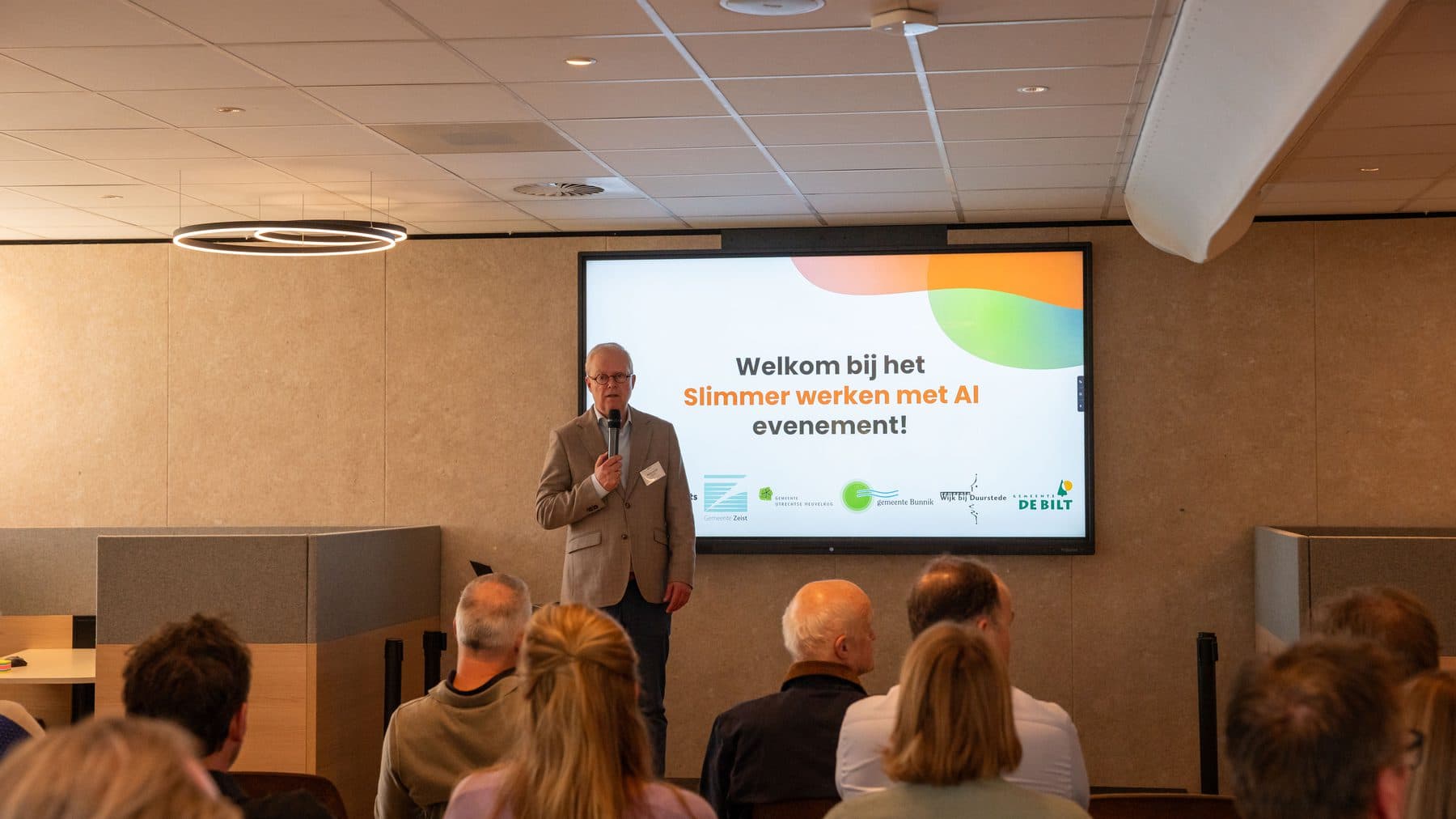 Bart Geurts opent de bijeenkomst bij Biga Groep in Zeist, met op het scherm het welkom bij Slimmer werken met AI